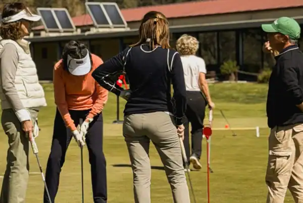 Clase de iniciación al golf en La Roca Golf, con instructor y alumnos practicando en el green