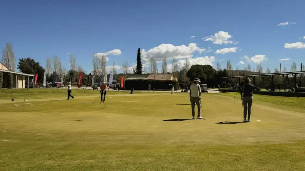 Putting green de La Roca Golf con golfistas practicando un día soleado en el Vallès Oriental, Barcelona