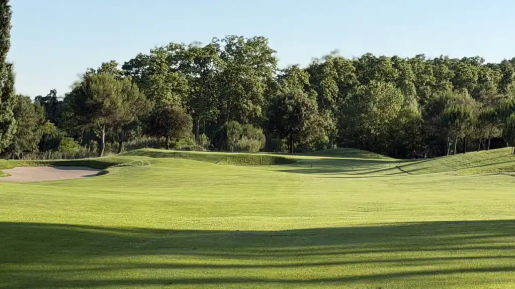 Green y bunker rodeados de arbolado en el campo de La Roca Golf, a 30 minutos de Barcelona