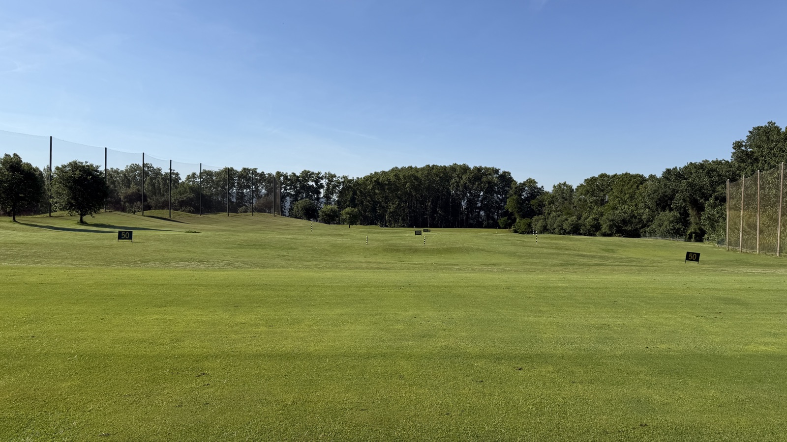 Zone de practice du driving range de La Roca Golf avec cibles de distance