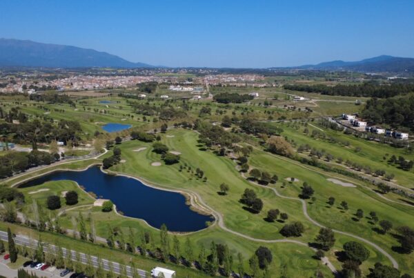 Aerial view of La Roca Golf showing its lakes and the access road, the Vallès Oriental town and the Montseny range in the background