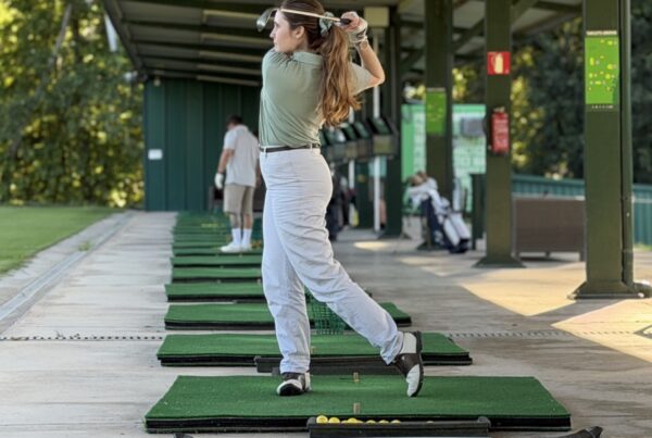 Jugadora acabant el swing de golf al driving range de La Roca Golf